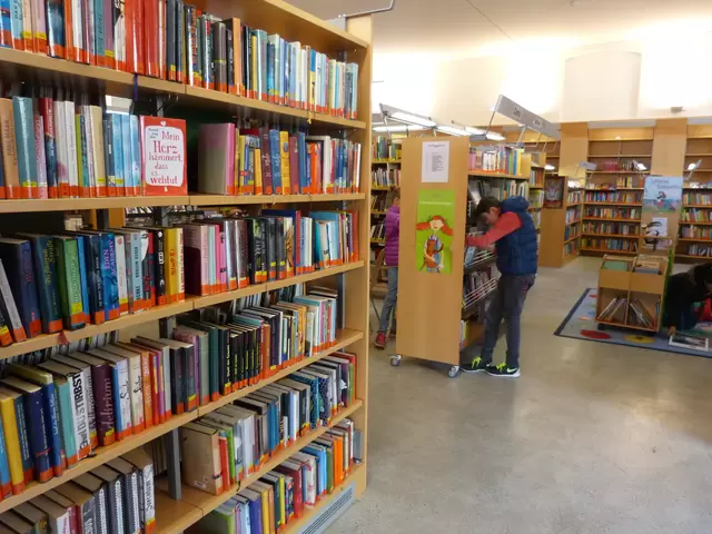 Ein junger Mann nimmt ein Buch aus dem Bücherregal der Bibliothek